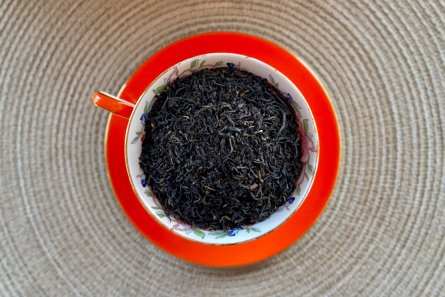 An orange teacup full of black tea