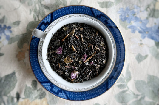 Teacup full of black tea and cherry blossoms 