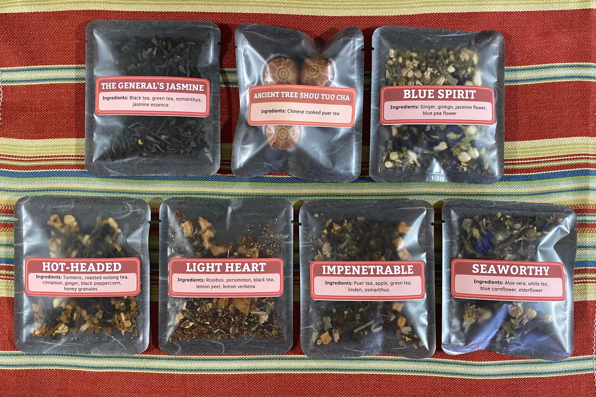 Seven Avatar-themed tea samples spread on a colorful cloth