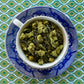Teacup full of matcha-dusted tea leaves