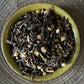 teacup full of tea leaves, barley and spice