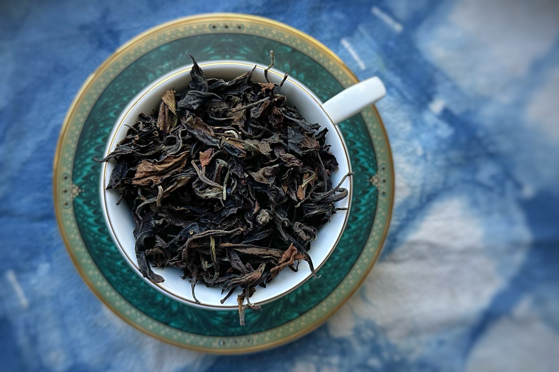 Teacup full of dark white tea leaf