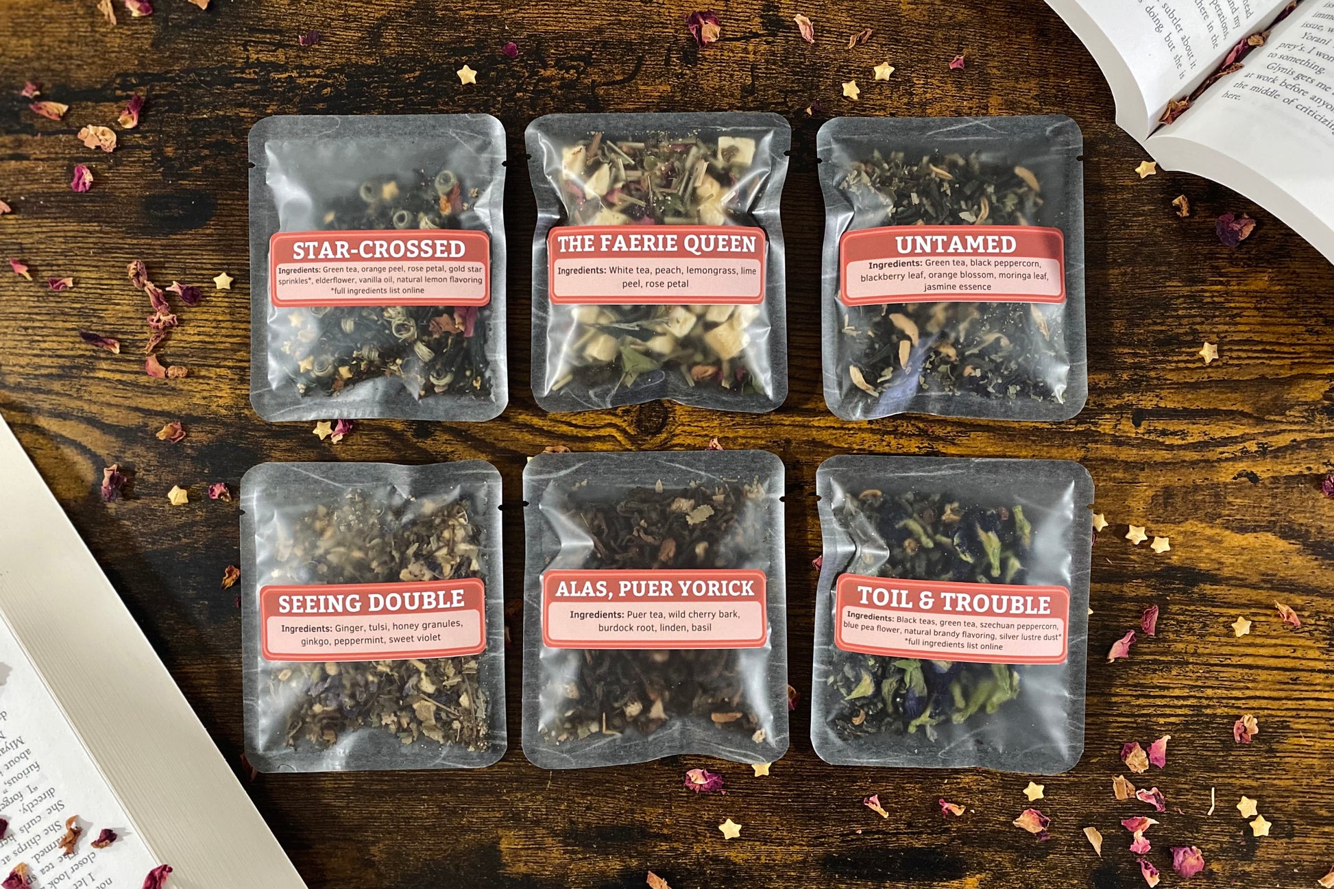 Six packages of tea on a wooden surface with visible text on labels