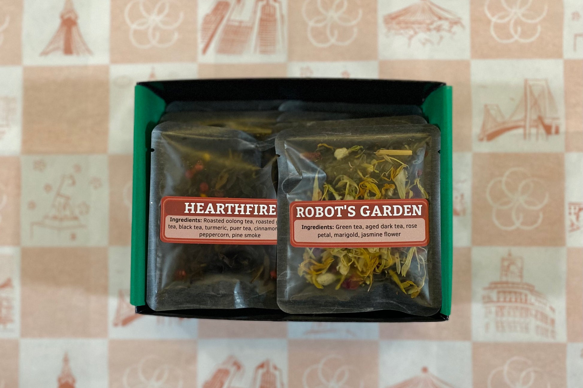 Two tea packages labeled 'Hearthfire' and 'Robot's Garden' on a patterned surface.