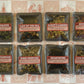 Eight packages of tea with labels on a patterned background
