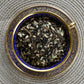 teacup full of black tea with cinnamon leaf