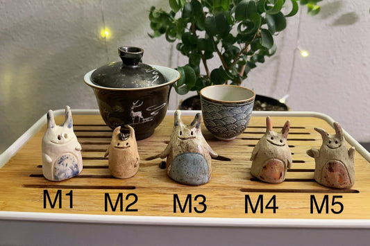 Five slug demon lookin tea pets on a bamboo tea tray